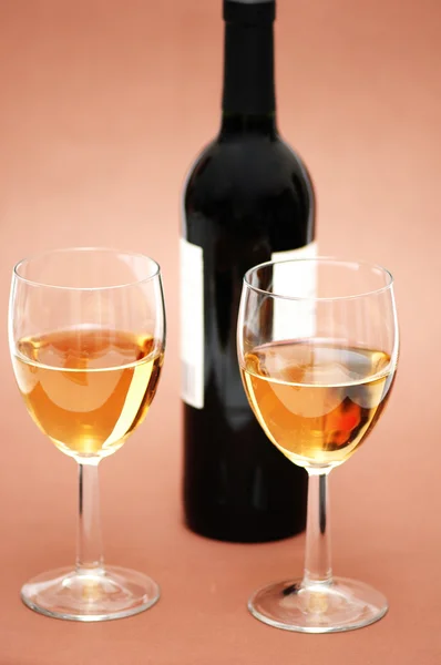 Två glas och flaska på biege — Stockfoto