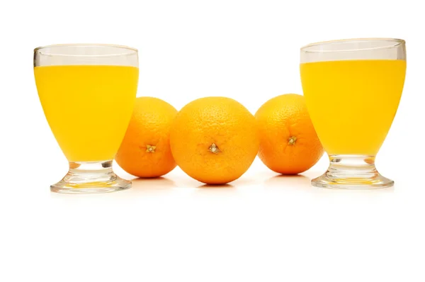 Три апельсина и апельсиновый сок — стоковое фото