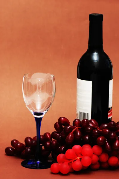 Ποτήρι κρασί, σταφύλια και μπουκάλι σε μπέζ — Φωτογραφία Αρχείου