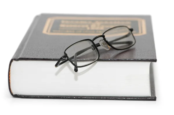 Leesbrillen over het boek geïsoleerd — Stockfoto
