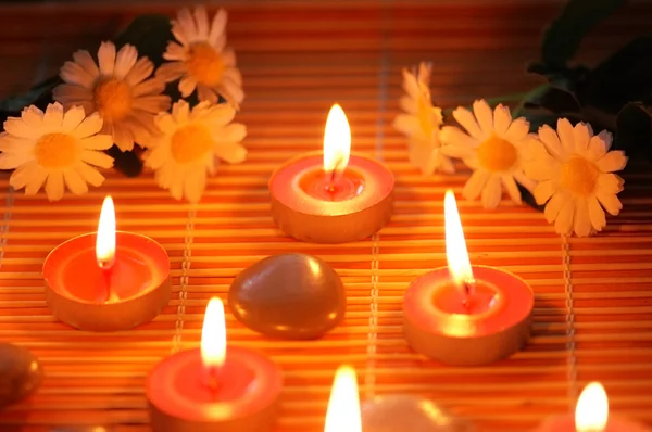 Kerzen, Blumen und Kiesel — Stockfoto
