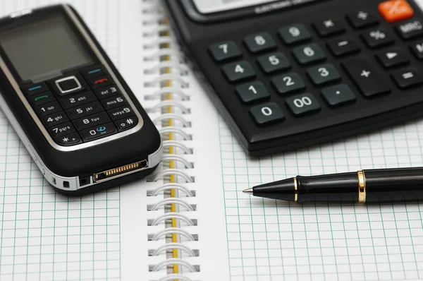 Mobiltelefon, miniräknare och penna — Stockfoto