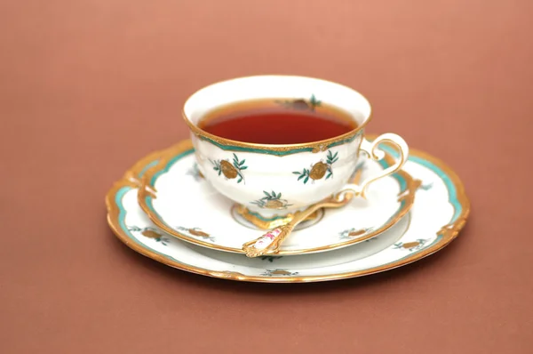 Kopp svart te, fat och sked — Stockfoto