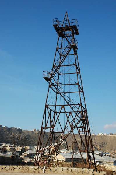Old oil derrick during bright summer day