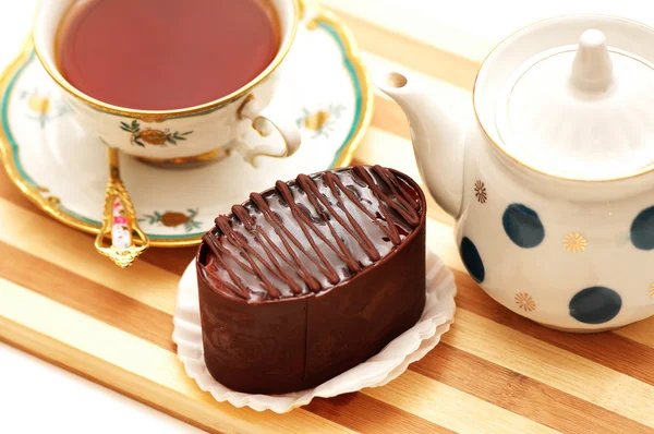 Csokoládé torta, vízforraló, és egy csésze tea — Stock Fotó