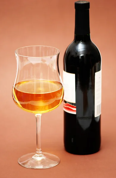 Copo de vinho e uma garrafa em biege — Fotografia de Stock