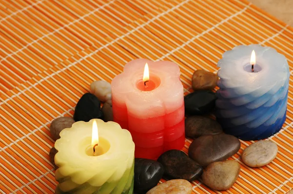 Drei Kerzen und Steine für den Wellnessbereich — Stockfoto