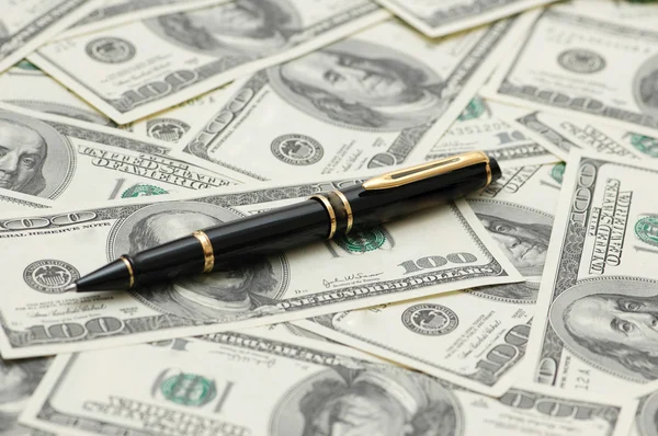 Černé kuličkové pero nad dolary — Stock fotografie