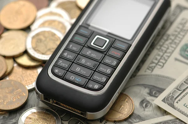Mobile phone with coins and dollars — Stock Photo, Image
