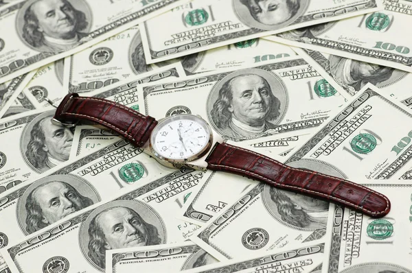 Relógio de mão sobre os cem dólares — Fotografia de Stock