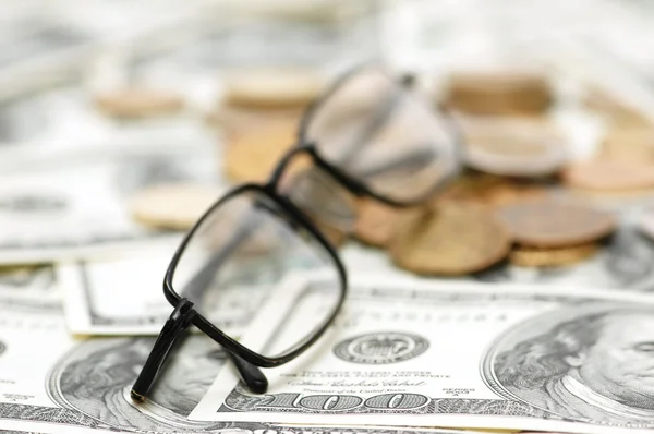 Reading glasses with coins — Stock Photo, Image