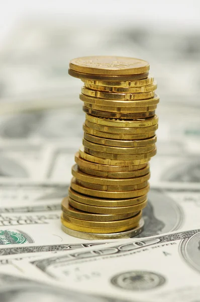 Stack of coins over the dollar bills — Stock Photo, Image