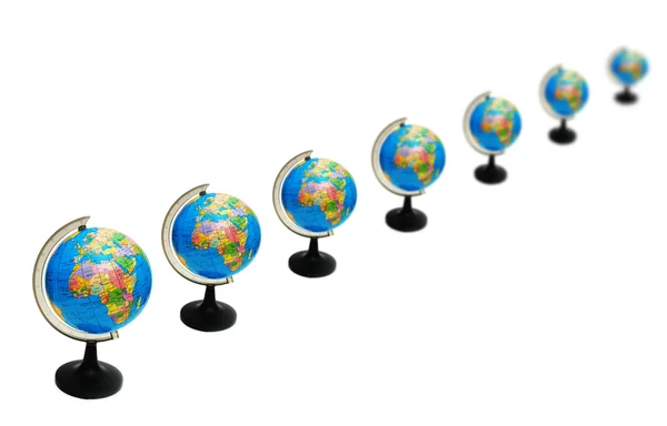 Globusy ułożone w rzędach, na białym tle — Zdjęcie stockowe