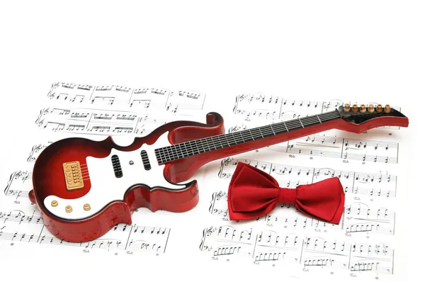 Notas musicales, guitarra y pajarita — Foto de Stock