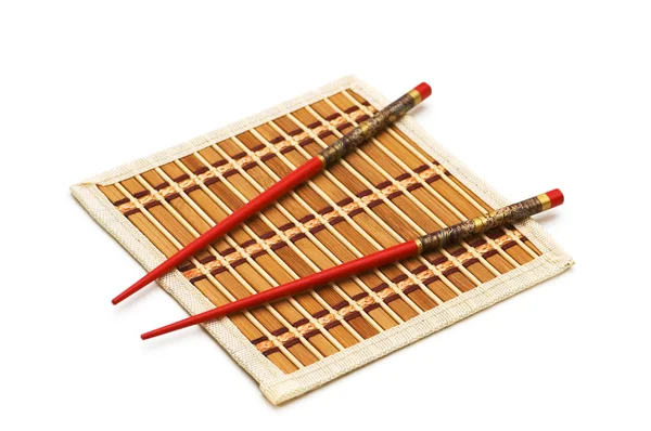 Red chopsticks on the mat — Stock Photo, Image
