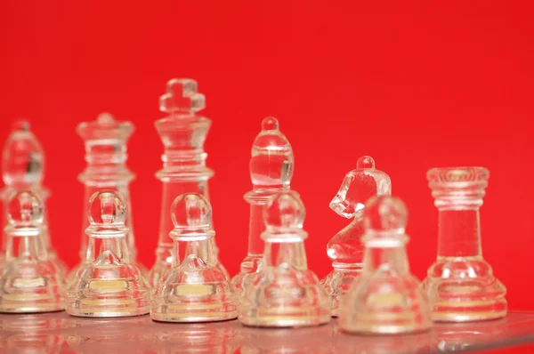 Různé šachové figurky proti červené — Stock fotografie