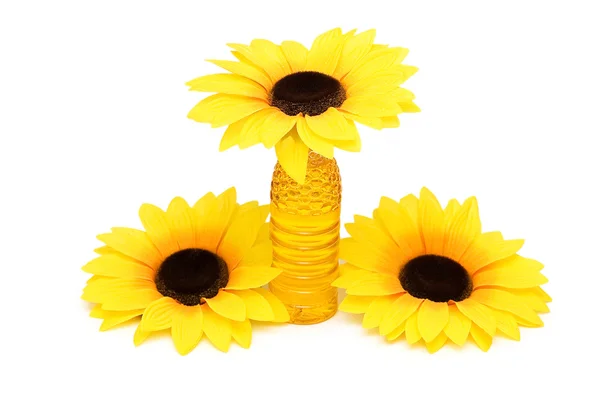 Three sunflowers and bottle of oil — Stock Photo, Image