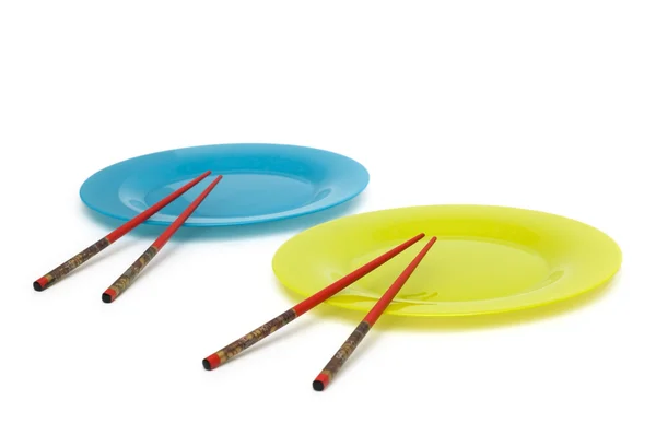 Blå og gule plater med spisepinner – stockfoto