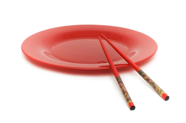 Rode plaat en eetstokjes geïsoleerd — Stockfoto