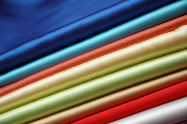 Pilha de tecido de cetim de várias cores — Fotografia de Stock