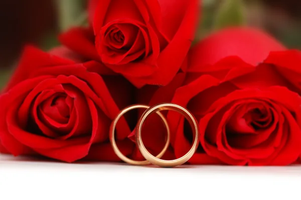 Two gold wedding rings and roses — Stock Photo, Image