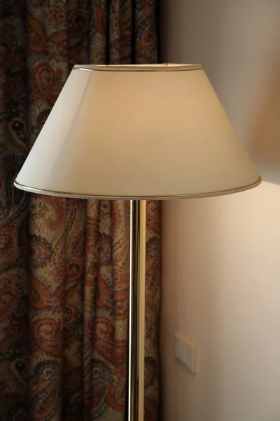 Lámpara de pie cerca de una pared en una habitación de hotel — Foto de Stock