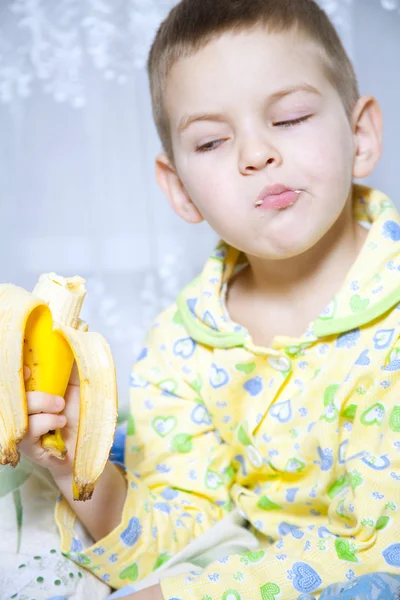 Мальчик ест банан — стоковое фото