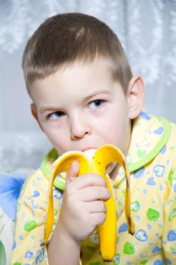 Boy eats a banana clipart