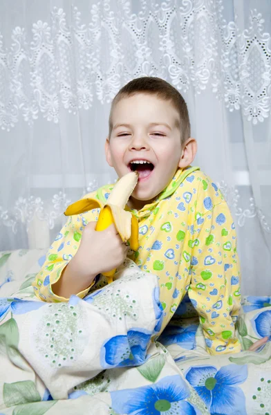 Chłopiec zjada banana — Zdjęcie stockowe