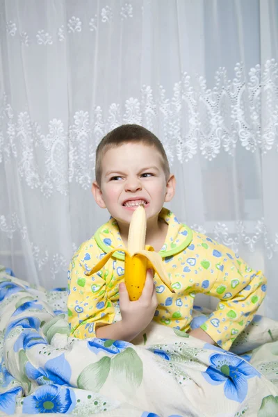 Chłopiec zjada banana — Zdjęcie stockowe