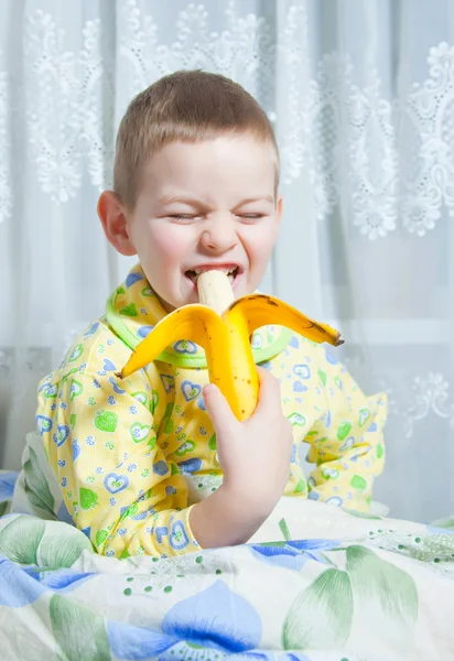 Un garçon mange une banane — Photo