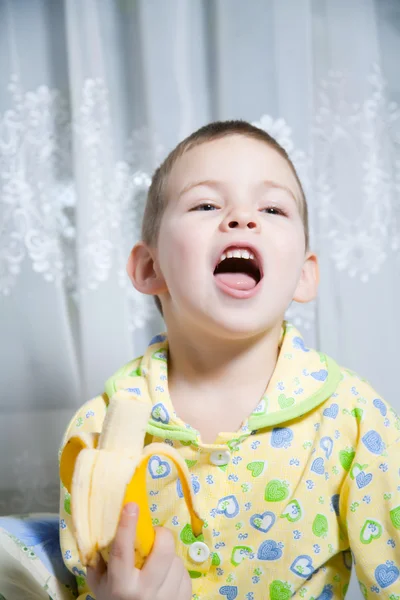 Pojke äter en banan — Stockfoto