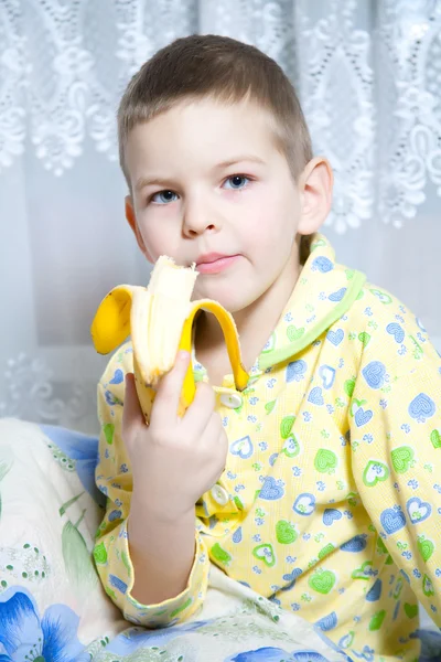 Ragazzo mangia una banana — Foto Stock