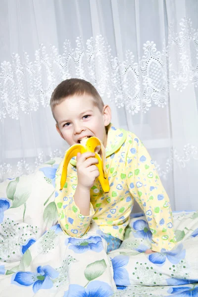 Хлопчик їсть банан — стокове фото