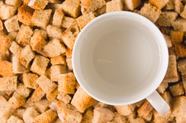 A mug of carbonated water among rusks clipart