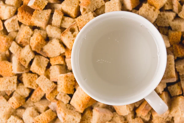 stock image A mug of carbonated water among rusks