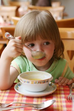 Charming little girl during a dinner clipart