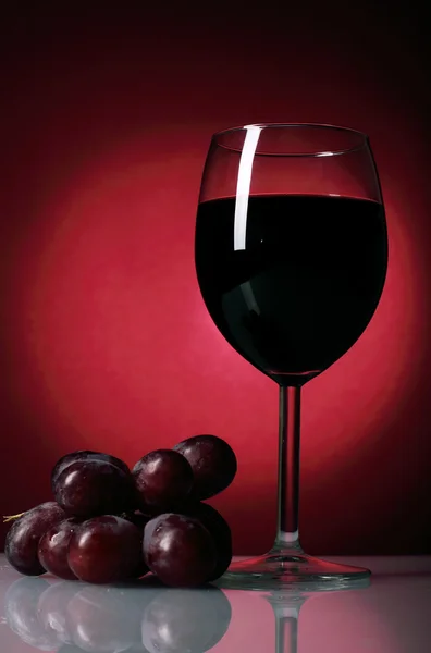 Copa de vino tinto y racimo de uvas — Foto de Stock