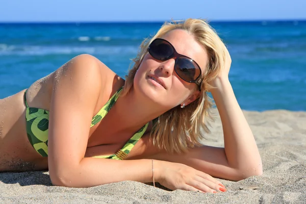 Hermosa chica se encuentra en la playa en el mar — Foto de Stock