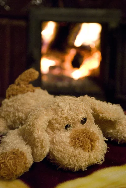 Şöminenin yanında oyuncak köpek yavrusu — Stok fotoğraf