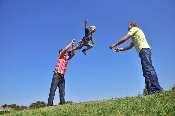 Father throwing his son in the air and c — Stock Photo, Image