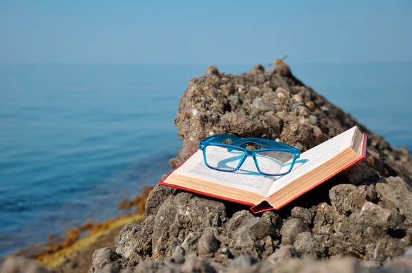 Книга с очками в отпуске — стоковое фото