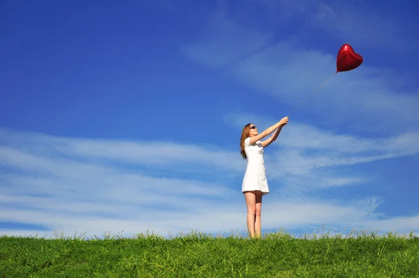 Девушка с красным мячом в виде слуха — стоковое фото