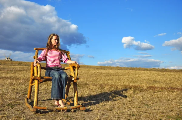 Girl in a wooden chair — Stock Photo, Image