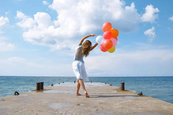 Счастливая девушка с воздушными шариками — стоковое фото