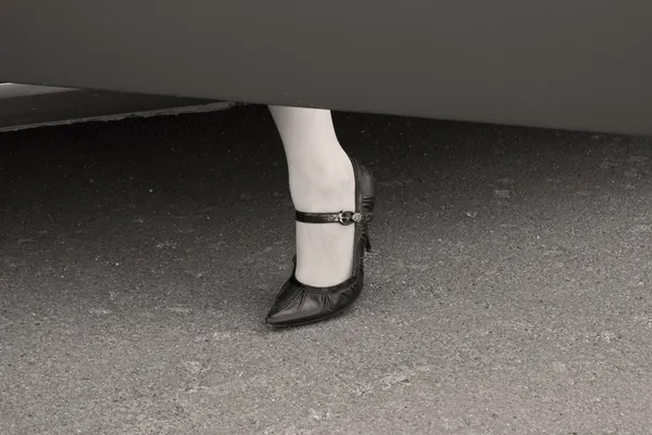 Pierna femenina en un zapato de tacón alto en un coche — Foto de Stock