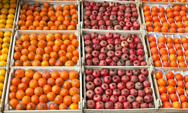 Persimmons and pomegranates in boxes — Stock Photo, Image