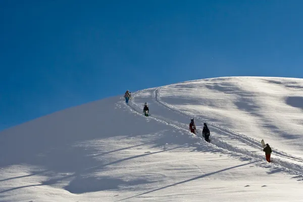 Snowboardziści chodzenie w góry — Zdjęcie stockowe
