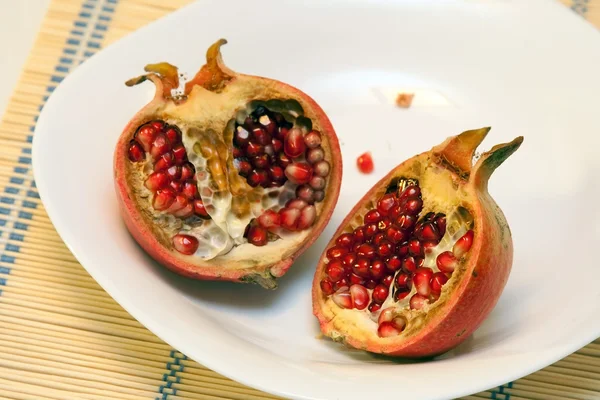 Pomegranates on white dish — Stock Photo, Image