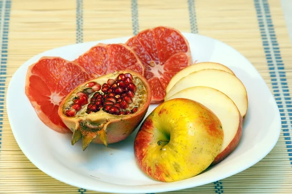 Sliced fruits on white dish — Stock Photo, Image